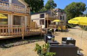 Zona de descanso exterior con sombrillas amarillas en Luxury lodge tent Belle Vue, La Draille, Francia.