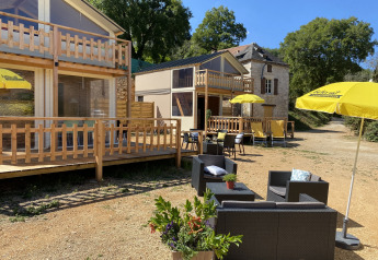 Coin salon extérieur avec parasols jaunes au Luxury lodge tent Belle Vue, camping La Draille, en France.