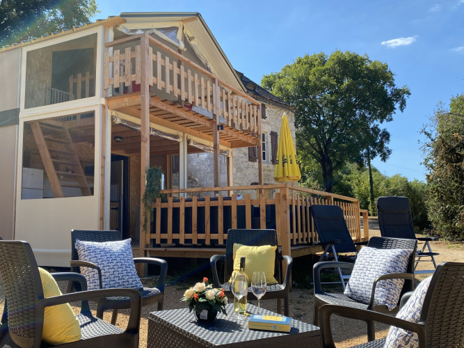 Zona de descanso exterior frente a la lujosa tienda safari Belle Vue en La Draille, Francia, en un día soleado.