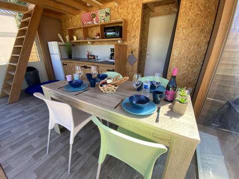 Essbereich und Küche in einem luxuriösen Safarizelt Belle Vue bei La Draille in Frankreich, vier Gedecke.