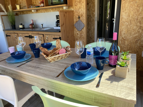 Mesa servida en la tienda lodge Belle Vue de La Draille, Francia, con pan, vino y menaje de cocina.