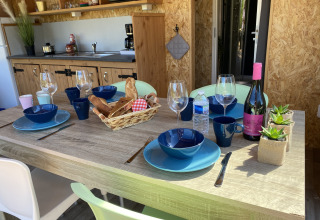 Mesa servida en la tienda lodge Belle Vue de La Draille, Francia, con pan, vino y menaje de cocina.