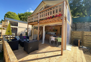 Tenda safari lodge di lusso Belle Vue a La Draille, Francia, con terrazza in legno e area salotto esterna.
