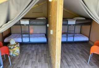 Innenaufnahme eines luxuriösen Safarizeltes bei La Draille in Frankreich mit Etagenbetten und Holzfußboden.