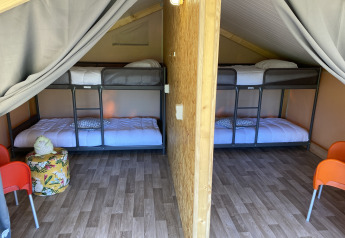 Innenaufnahme eines luxuriösen Safarizeltes bei La Draille in Frankreich mit Etagenbetten und Holzfußboden.