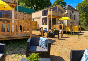 Outdoor seating and luxury safari lodge tent Belle Vue with yellow umbrellas at La Draille in France.
