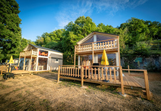 Luxury lodge tent Belle Vue at La Draille in France, with wooden deck and scenic forest background.