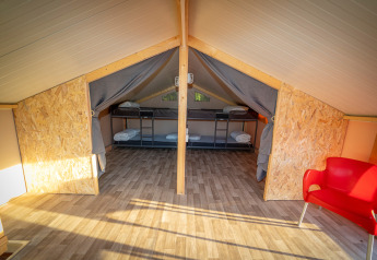 Indretning af luksus lodge telt Belle Vue på La Draille i Frankrig med køjesenge og rød stol.