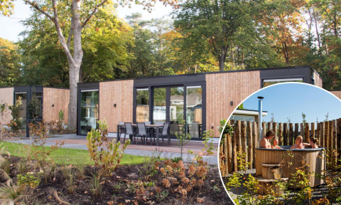 Veluwehoeve Wellness-lodge met buitenterras en ronde houten hottub in een groene, bosrijke omgeving.
