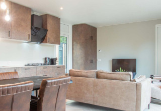 Lodge moderno con cocina abierta, comedor y sala de estar en Veluwehoeve Wellness (Hottub).