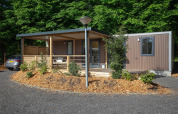 Moderne familie cottage bij De Thijmse Berg in Nederland met houten gevel, veranda en omgeven door natuur.