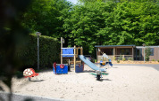 Spielplatz mit Rutsche und modernen Geräten vor Family Cottage auf De Thijmse Berg, Niederlande.