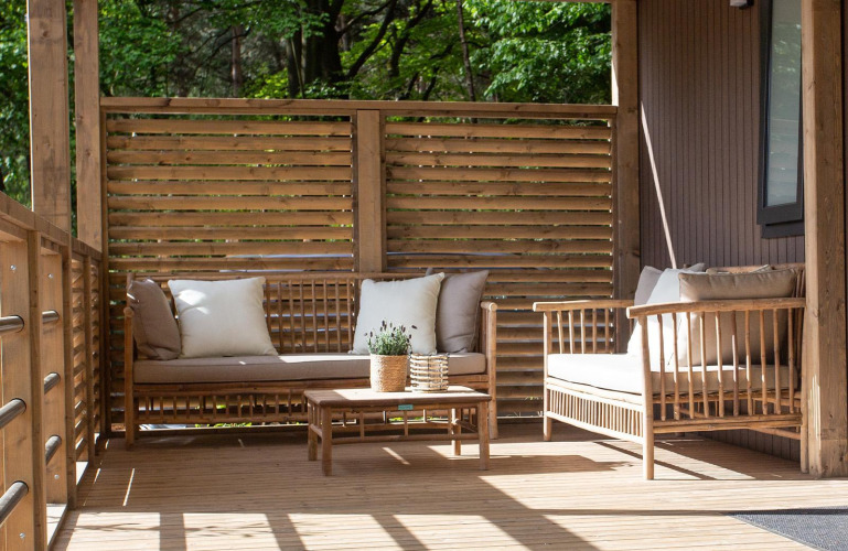 Gemütliche Terrasse beim Family Cottage, De Thijmse Berg, Niederlande, mit Holzmöbeln und Kissen.