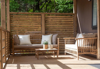 Outdoor seating area at Family Cottage, De Thijmse Berg in the Netherlands with wooden furniture.