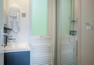 Baño moderno en Family Cottage de De Thijmse Berg, Países Bajos, con lavabo, ducha y secador de pelo.
