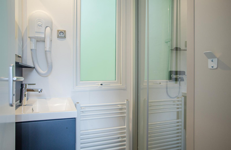 Baño moderno en Family Cottage de De Thijmse Berg, Países Bajos, con lavabo, ducha y secador de pelo.