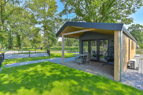 Vista de un lodge de lujo con terraza y jardín, accesible para sillas de ruedas, en Drentse Weelde, Países Bajos.