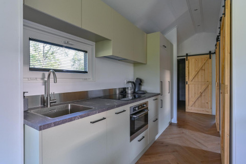 Barrierefreie Luxus-Lodge-Küche in Drentse Weelde, Niederlande, mit Holz-Schiebetür und modernen Geräten.