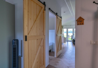 Vista interior de la Luxury lodge en Drentse Weelde con puertas correderas de madera y acceso para sillas de ruedas.