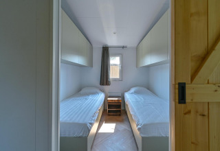Habitación accesible con dos camas individuales y armarios blancos en Luxury Lodge de Drentse Weelde, Países Bajos.