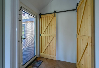 Entrée avec porte vitrée et deux portes coulissantes en bois au Luxury lodge - accessible en fauteuil roulant à Drentse Weelde, Pays-Bas.