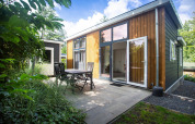 Moderne Nature Lodge ved De Thijmse Berg i Holland med terrasse, havemøbler og grønne omgivelser.