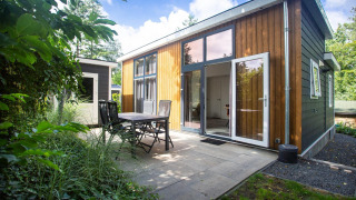 Moderne Nature Lodge am De Thijmse Berg in den Niederlanden mit Terrasse, Stühlen und viel Natur.