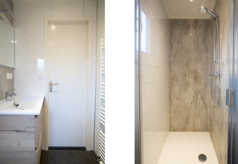 Salle de bain moderne avec lavabo, miroir et douche à la Nature Lodge de De Thijmse Berg, Pays-Bas.
