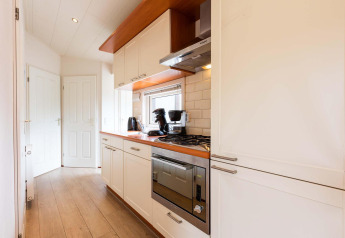 Moderne, smalle keuken in een vakantiehuis bij EuroParcs Noordwijkse Duinen, Nederland, houten blad.