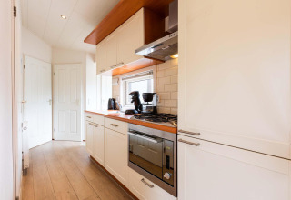 Cucina moderna e stretta in una casa vacanze a EuroParcs Noordwijkse Duinen nei Paesi Bassi.