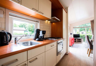 Cuisine moderne et salon d'une maison de vacances à EuroParcs Noordwijkse Duinen, Pays-Bas, en journée.