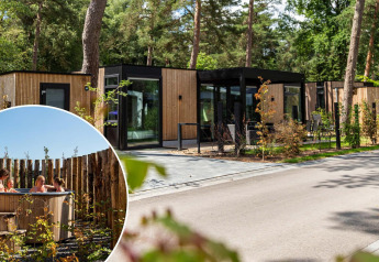 Cabines de glamping modernes en forêt avec bain à remous privé extérieur et ambiance détendue.