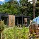 Wellness-lodge Veluwe Farm bij Resort Veluwe, Nederland, met hottub te midden van het groene bos.