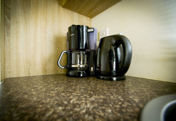 Macchina da caffè e bollitore elettrico sul piano di lavoro alla Forest Lodge, Holiday Park Duinhoeve, Paesi Bassi.