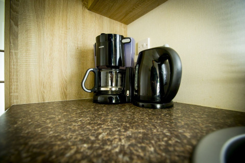 Kaffemaskine og elkedel på køkkenbord i Forest Lodge, Holiday Park Duinhoeve, Nederlandene.