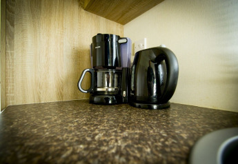 Macchina da caffè e bollitore elettrico sul piano di lavoro alla Forest Lodge, Holiday Park Duinhoeve, Paesi Bassi.