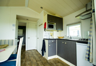 Bright, modern kitchen area inside Delta Lodge at Holiday Park Duinhoeve, Netherlands, with dining nook.