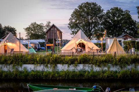 Happy Harbor Tipi-Zelt mit Bad im Holiday Park Mölke, Niederlande, bei abendlicher Beleuchtung.