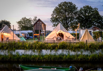 Tenda tipi Happy Harbor con bagno al Holiday Park Mölke, Paesi Bassi, con atmosfera serale suggestiva.