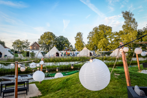 Udsigt over tipi-telte og pyntede lanterner ved Happy harbor telt med badeværelse i Holiday Park Mölke, Holland.