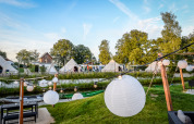 Vue sur des tipis et des lanternes décoratives près de la tente Happy harbor avec salle de bain au Holiday Park Mölke, Pays-Bas.