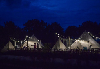 Beleuchtete Happy Harbor-Tipizelte bei Nacht im Holiday Park Mölke in den Niederlanden.