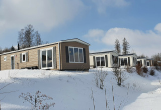 Cabañas Chalet Brilon cubiertas de nieve en Camping & Ferienpark Brilon, Alemania, con paisaje invernal.