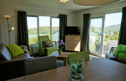 Lichte woonkamer in Chalet Brilon op Camping & Ferienpark Brilon, Duitsland, met zicht en groene tinten.