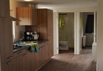 Acogedora cocina de madera con electrodomésticos modernos en Chalet Brilon, Camping & Ferienpark Brilon, Alemania.