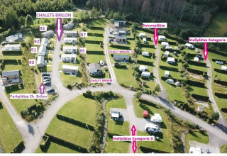 Vista aérea del Chalet Brilon con cabañas, espacios de estacionamiento y parcelas de camping etiquetadas.