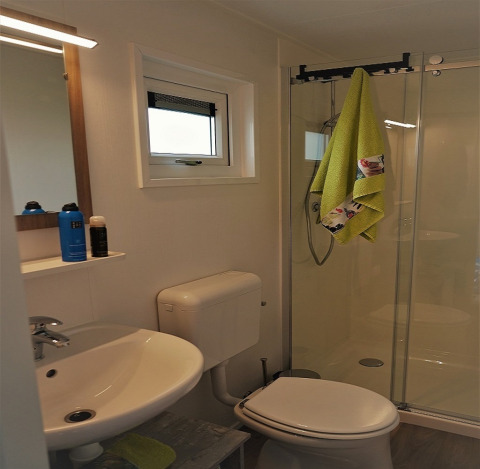 Baño moderno en Chalet Brilon, Camping & Ferienpark Brilon, Alemania, con ducha, inodoro y lavabo.