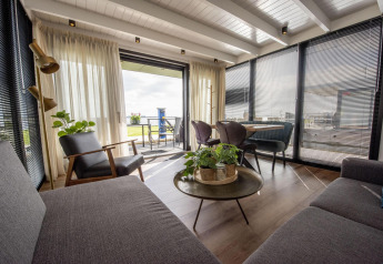 Sala moderna y luminosa en la casa flotante 'De Waterparel' con vistas al agua en Friesland, Países Bajos.