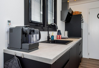 Moderne woonbootkeuken met koffiemachine en spoelbak, genomen in Houseboat 'De Waterparel' in Friesland, Nederland.