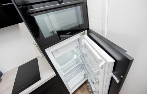Horno empotrado y frigorífico abierto en la cocina del houseboat 'De Waterparel' en Friesland, Países Bajos.
